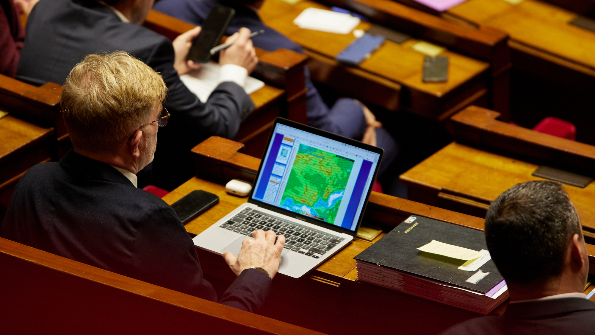 nhân viên chính phủ Pháp sử dụng laptop trong phiên họp (đại diện cho hệ thống hành chính mới).